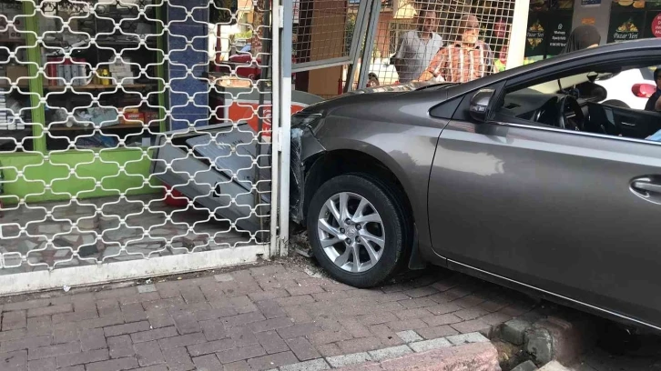 Çarpışan otomobillerden biri marketin kepenklerine girdi, o anlar kamerada
