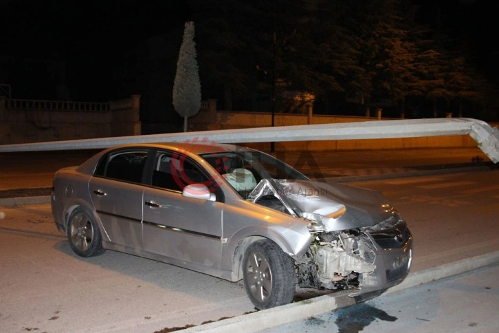 Çarptığı direk otomobilin üzerine devrildi