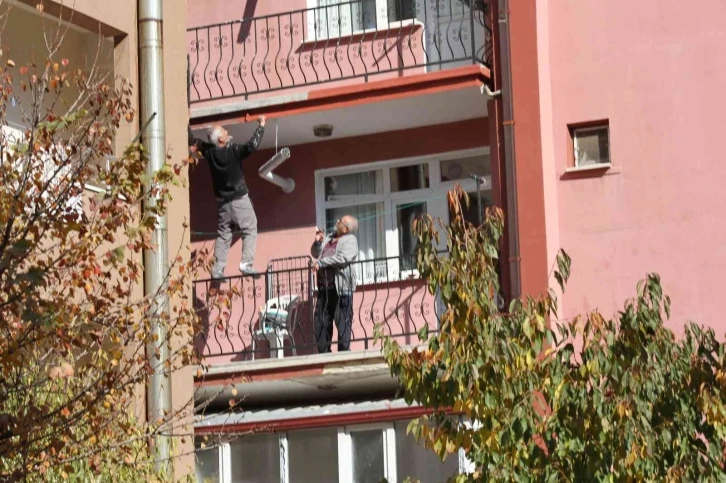 Çatıda yatarak sıva yapan usta bu kez de balkon demirine çıkıp boya yaptı
