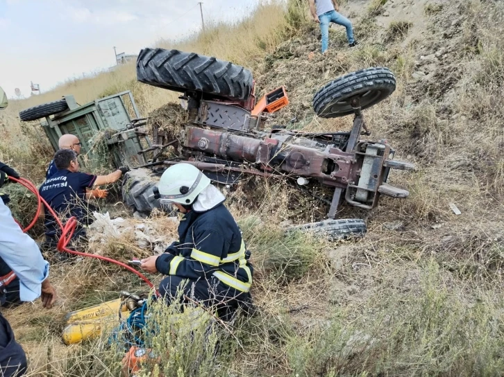 Devrilen traktörün altında kalan sürücüyü itfaiye ekipleri kurtardı
