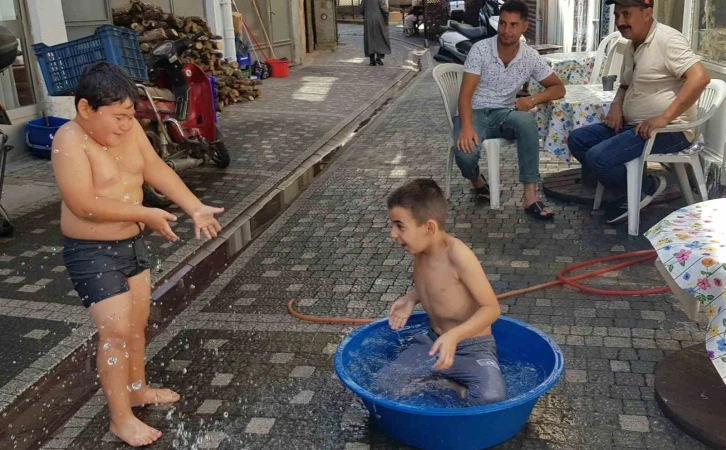 Edremit’te sıcaktan bunalan çocuklar leğende serinledi
