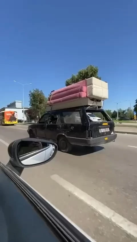 Ehliyetsiz sürücü otomobilin tavanında koltuk taşıdı
