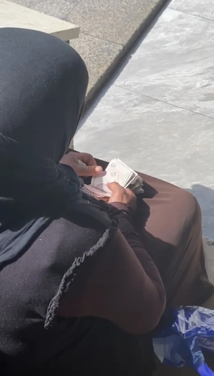 Taksim’de hasılatı sayan dilenci kadın kamerada
