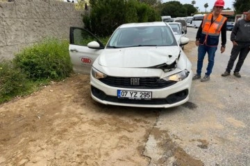 Devrilen iş makinesinin kepçesi otomobilin kaputunun üzerine düştü