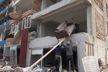 Hatay’da yıkılmak üzere olan 4 katlı binadan eşya taşıma anları kamerada