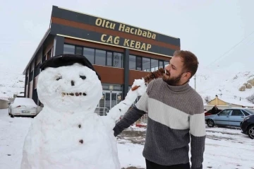 Kardan adam, iş yerine gelenleri cağ kebabı ile karşılıyor
