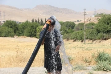 Mardin’de sıcaktan bunalan vatandaş tarım sulama hortumu ile serinledi
