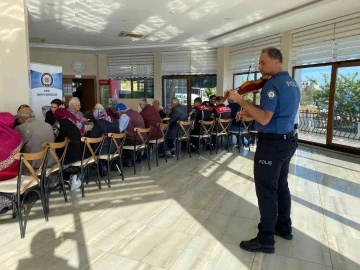 Polis memurunun belinde silah, omzunda keman
