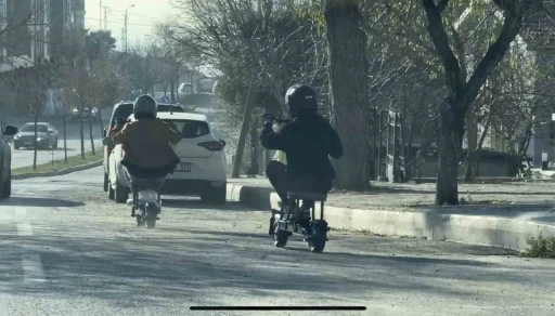 Trafikte ilginç anlar: Taburenin üzerine oturarak elektrikli scooter kullandılar
