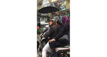 Yağmurda kendisi ıslanma pahasına kocasını şemsiyeyle korudu